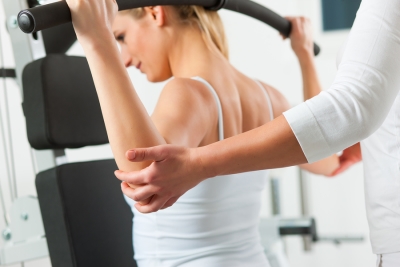 trainer helping woman with physical therapy for back